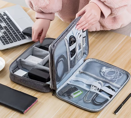 Neceser organizador de cables abierto con cargador, cables y auriculares ordenados en gomas elásticas